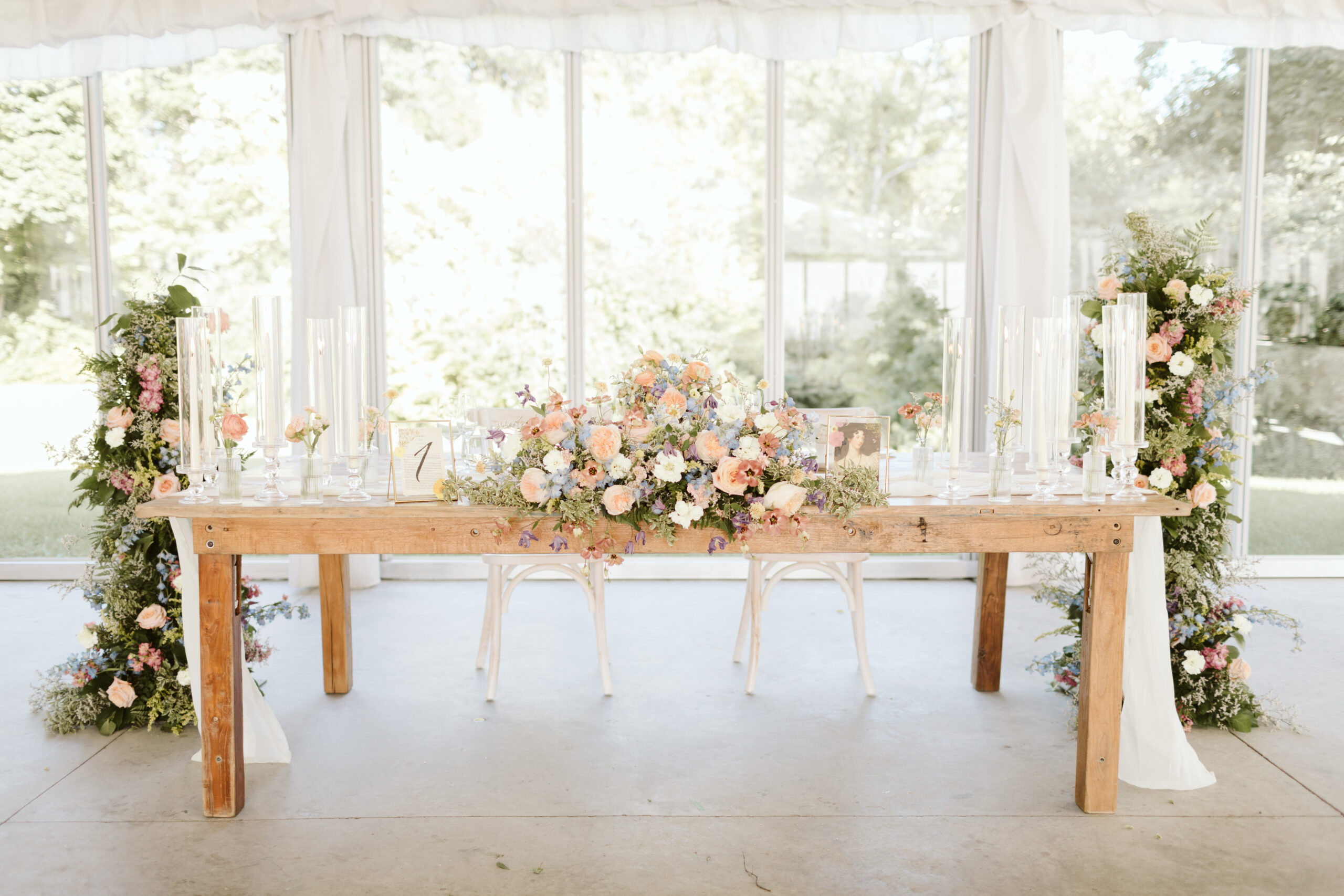 Sweetheart table with garden party florals and bookish wedding table numbers. Photo by Maddie Mellott Photography.